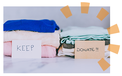 Piles of clothing labeled keep and donate.