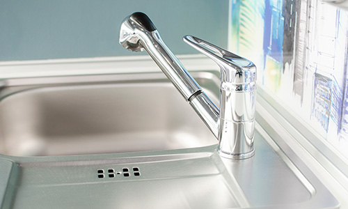 A stainless steel kitchen sink and faucet.