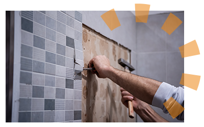 Bathroom tile being chiseled off a wall.