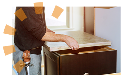 A man places laminate counters on base cabinets to check the fit.