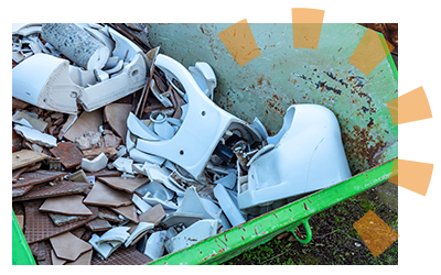 A broken toilet in a bin for recycling.