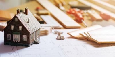 Model Home on Top of Contractor’s Remodeling Blueprints