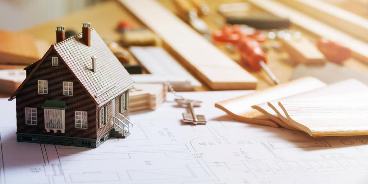Model Home on Top of Contractor’s Remodeling Blueprints