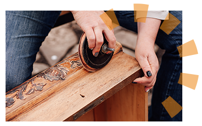 A person sanding down a dresser drawer to upcycle it. 