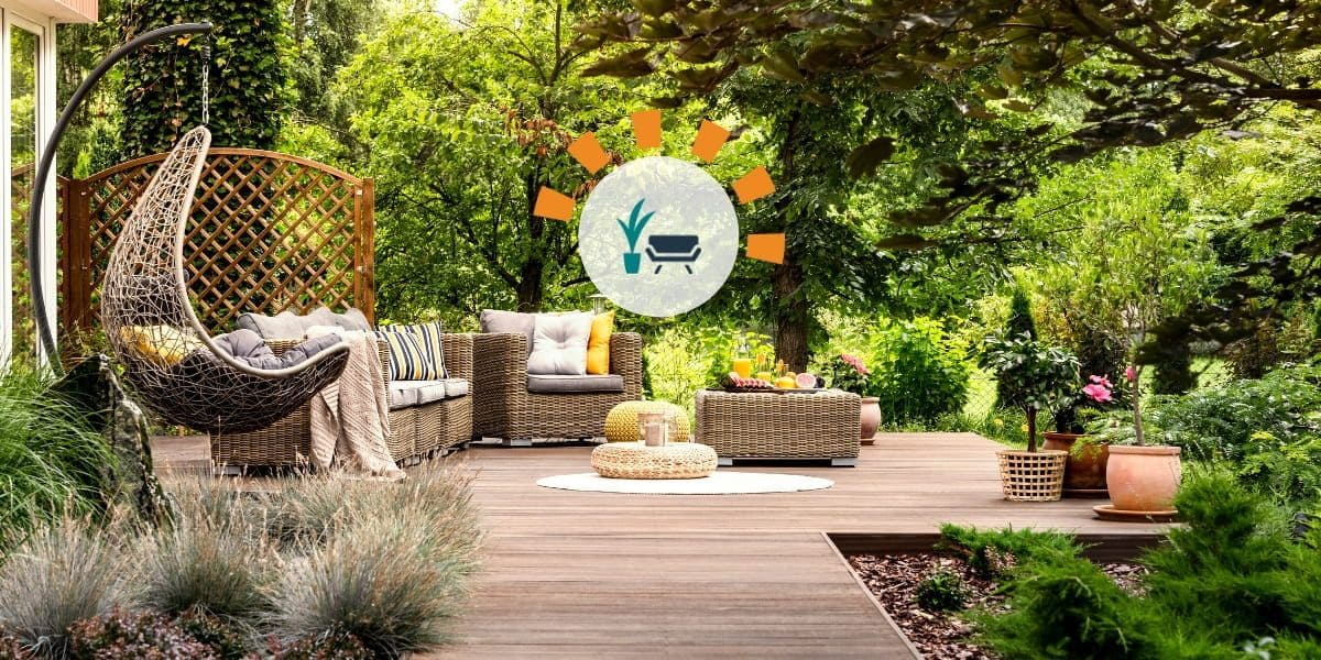 Updated backyard with wooden terrace, garden with potted flowers and wicker swing chair.