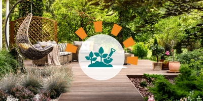 Updated backyard with wooden terrace, garden with potted flowers and wicker swing chair. 