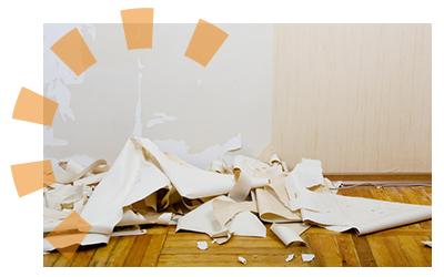 A pile of removed wallpaper scraps on the ground.