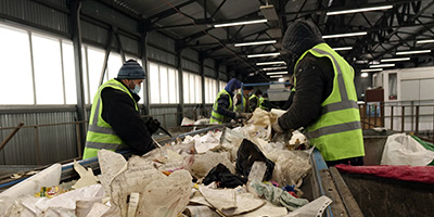 Waste Processing Plant Workers Sorting Trash