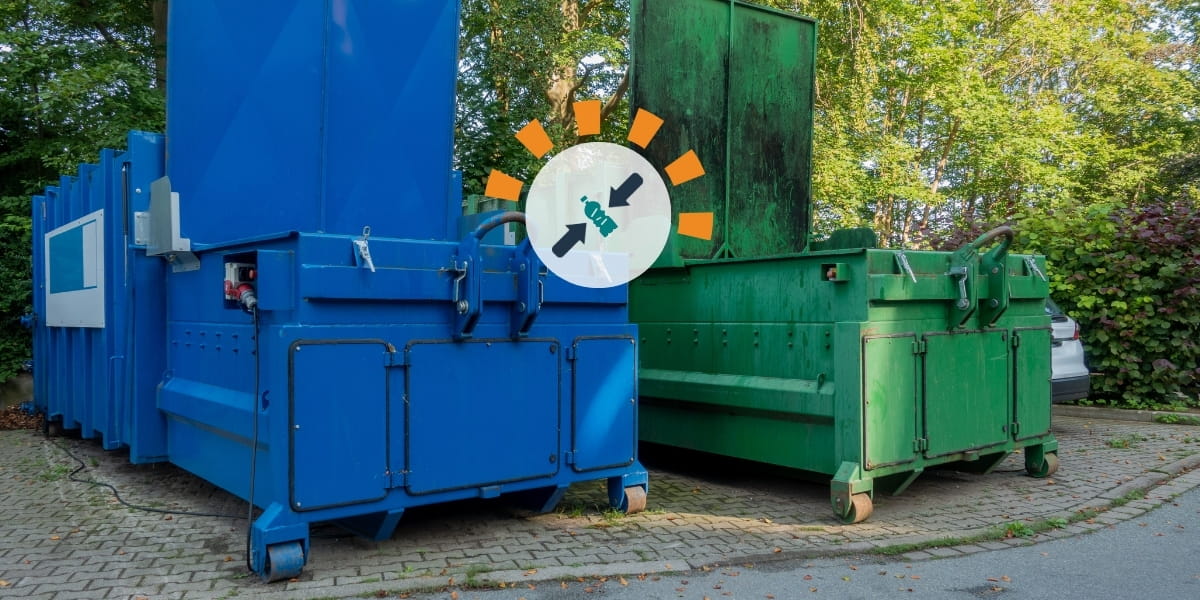 Two compactor dumpsters sitting next to each other