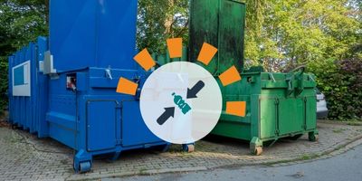 Two compactor dumpsters sitting next to each other
