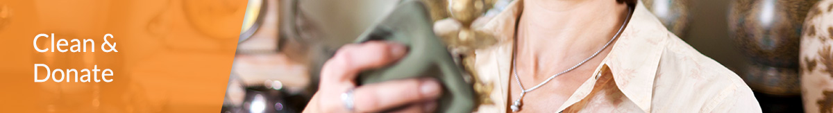 White text 'Clean & Donate' over image of an auburn-haired woman cleaning candle holder from estate sale to donate.