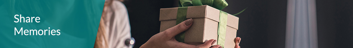 Woman holding a box wrapped in a green box for a loved one with text that says 