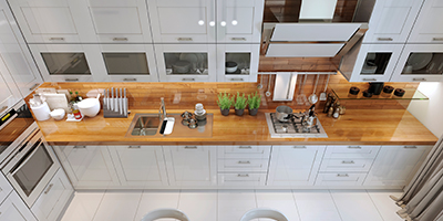 Overhead view of modern kitchen with wood countertops and white cabinets.