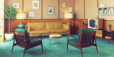 Retro home interior with wood panel walls, bright green carpet and midcentury modern furniture.