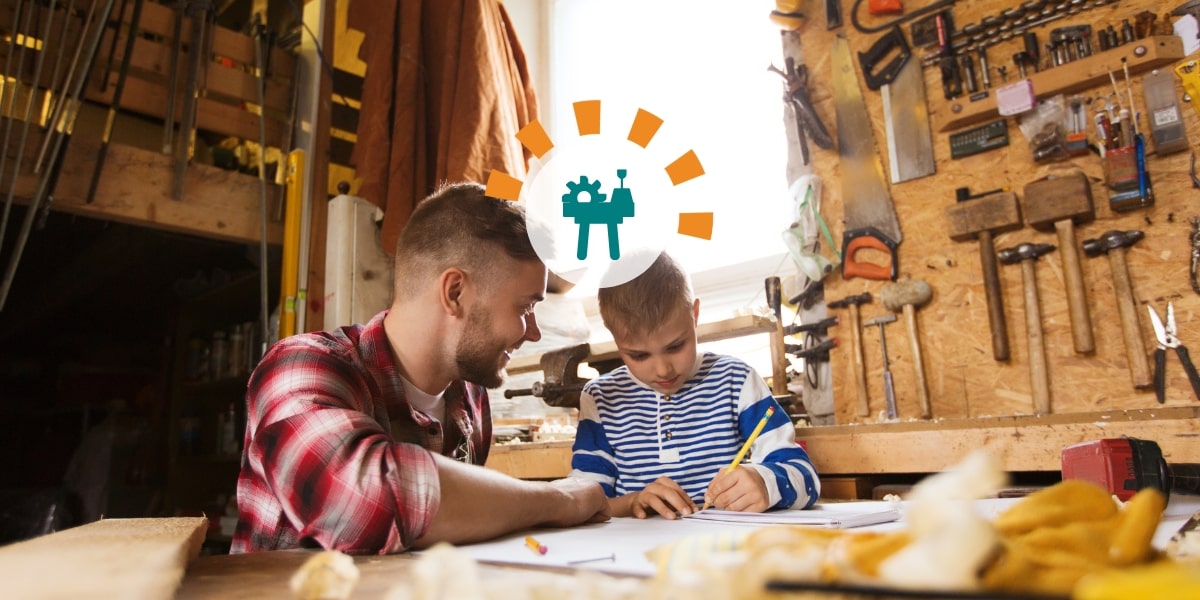A dad helps his son with a design project at the garage workbench.