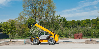 Yellow forklift on empty construction site.