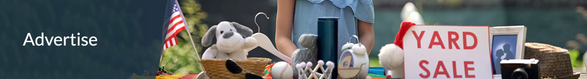 Young girl standing at a table with old toys at a yard sale in front of her home.