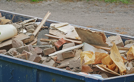 Dumpster filled with bricks and other construction materials.