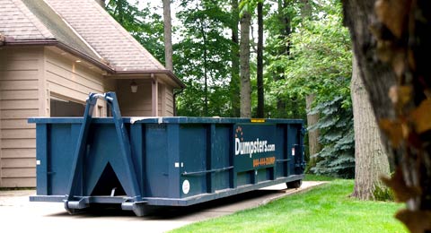 A Blue Roll Off Dumpster Sitting in a Driveway.