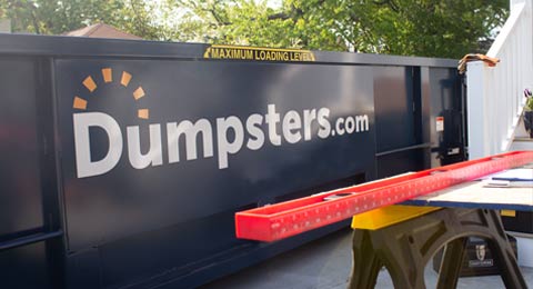 Dumpsters.com Construction Dumpster With Tools in Foreground.