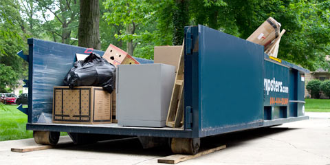 Roll Off Dumpster Filled With Junk in Residential Driveway.