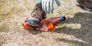 boot crushing a brown plastic bottle