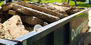 Chunks of Concrete in a Blue Dumpsters.com Roll Off Dumpster.