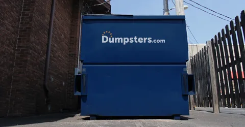 Dumpsters.com dumpster behind a building.