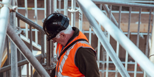 Construction engineer looking at an iPad with a crane in the background