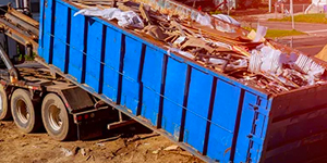 Full dumpster being loaded onto a truck.