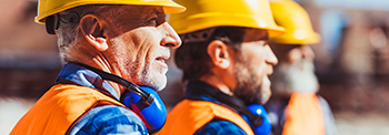 Three Construction Workers With Yellow Hard Hats.