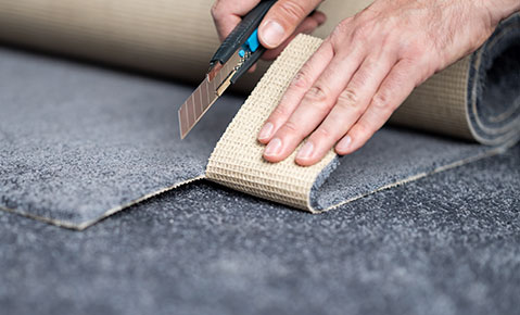 Person Pulling Up Carpet With Knife
