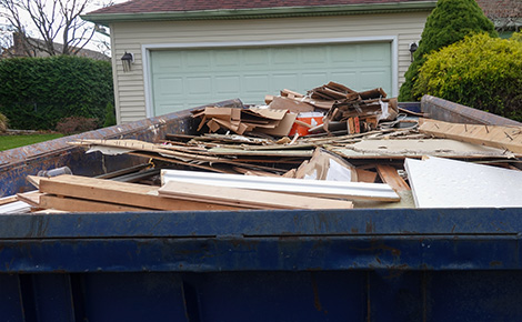 Dumpster containing large amounts of lumber