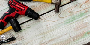 drill and hammer laying on luxury vinyl flooring tiles