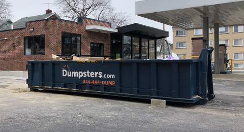 large dumpster on street filled to the top