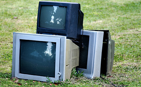 A Pile of Televisions on a Tree Lawn