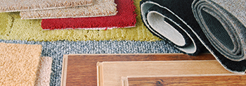 Rolls of Carpet Near Panels of Hardwood.