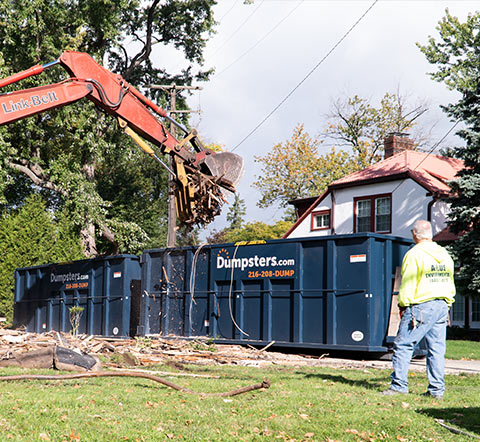 Large Roll Off Dumpster Being Filled By Demolition Equipment