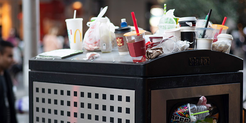 outdoor trash can overflowing with garbage