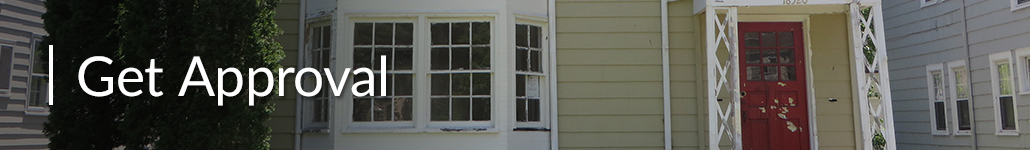 The Front of a Historic Home Before it Is Repaired with a Marked Up Red Door, an Old Porch and Windows in Need of Repair.