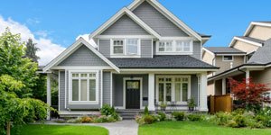 Beautiful Gray Home With Blue Skies and Green Grass.