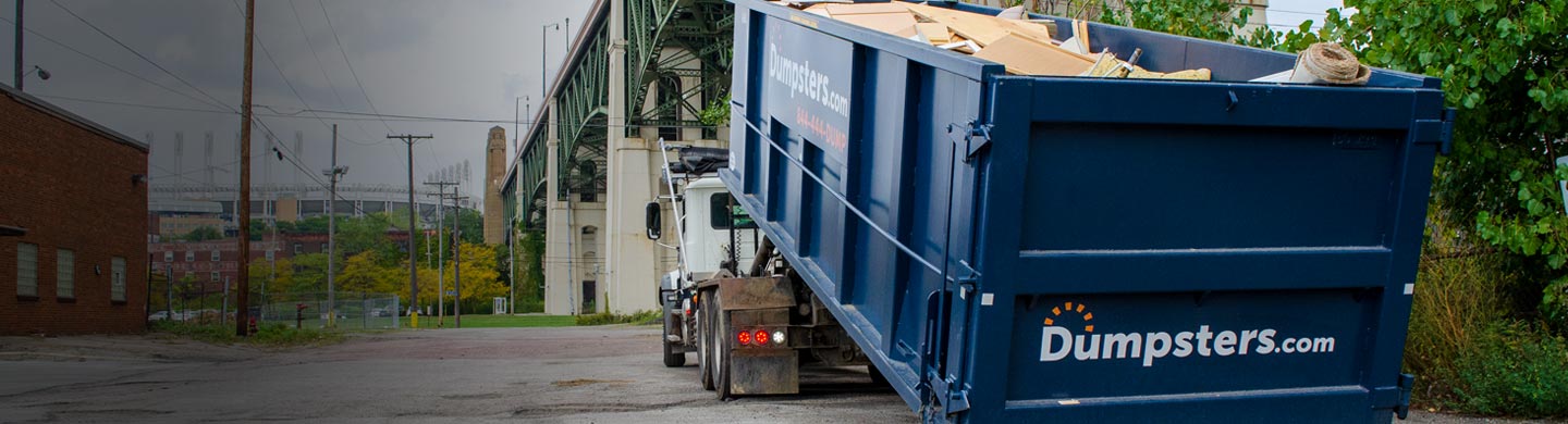 Remodeling Debris in a Dumpsters.com Roll Off Dumpster with the Lorain-Carnegie Bridge and Progressive Field in the Background.