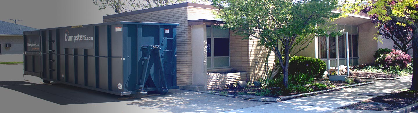 roll off dumpster with dumpsters.com logo placed next to an office building