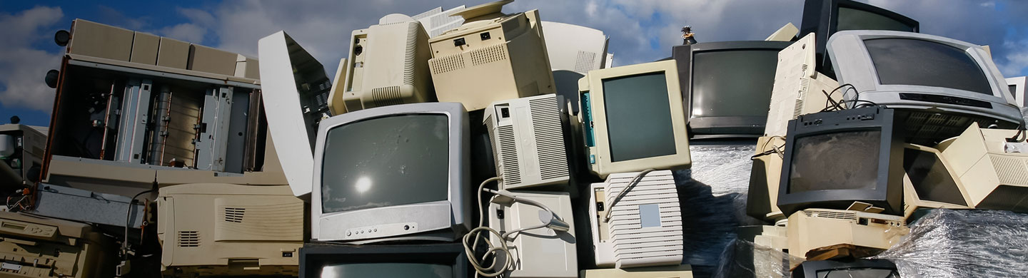 a pile of tube televisions and computer monitors