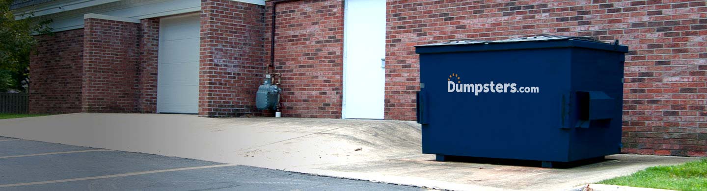 A Blue Front Load Bin Sits Behind a Retail Shop