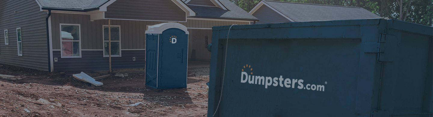 Dumpsters.com portable toilet and dumpster on a jobsite.