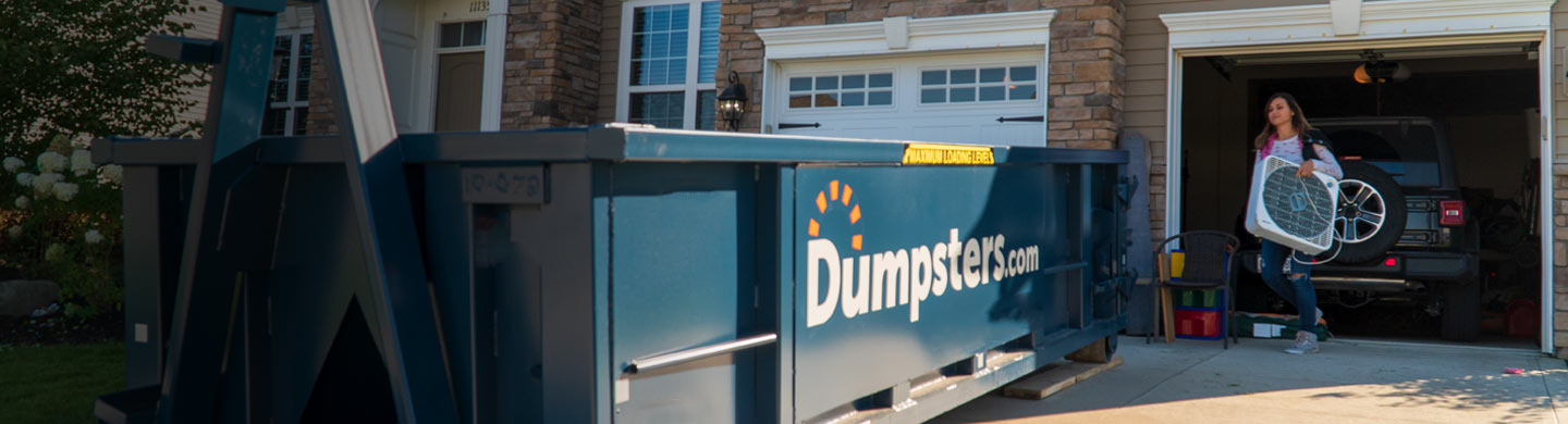 mother and daughter loading household junk into a residential dumpster rental