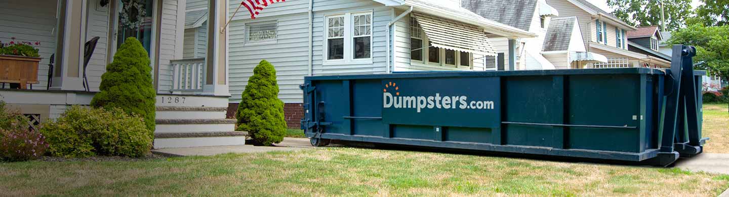 Roofing Dumpster in Driveway Between Houses