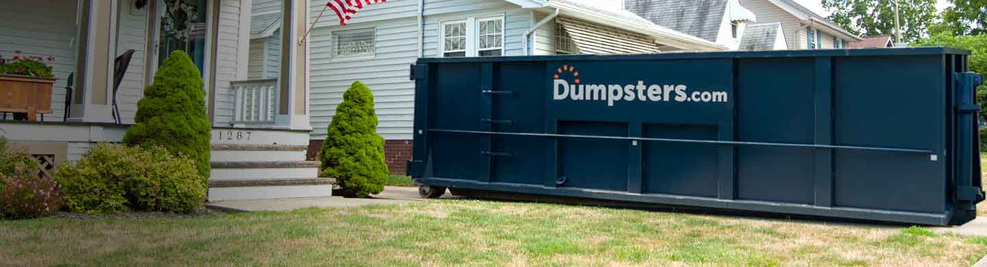 Blue Roofing Dumpster in the Driveway of a White House