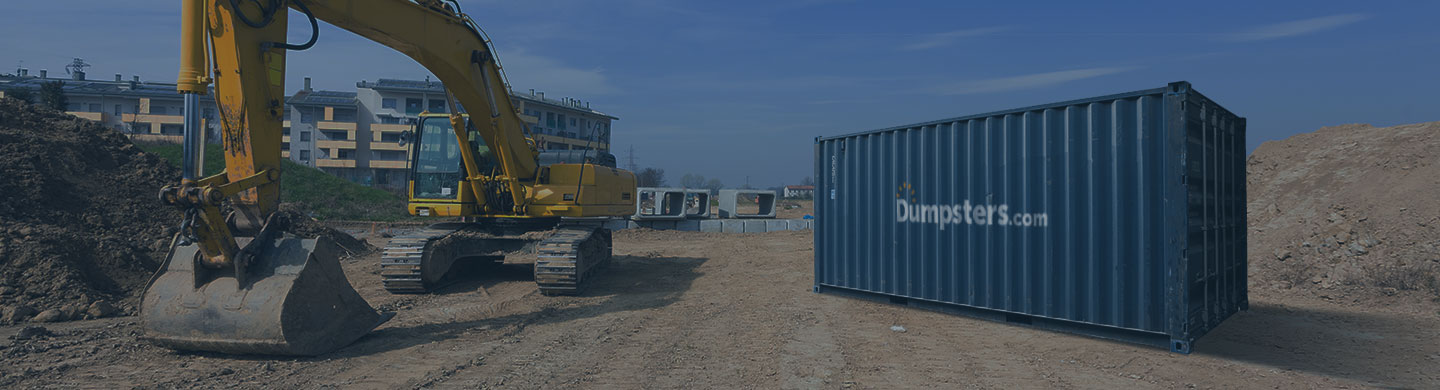 Dumpsters.com storage container sitting next to a yellow excavator on an active construction site.